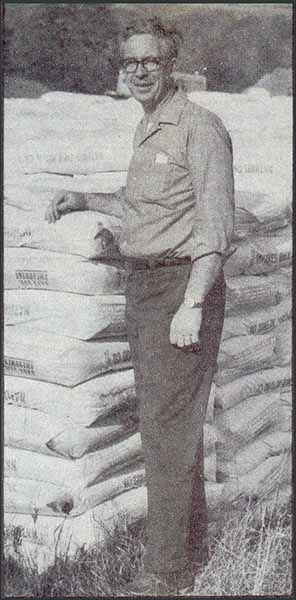 Nate Morrell standing beside bags of his bark soil amendment.